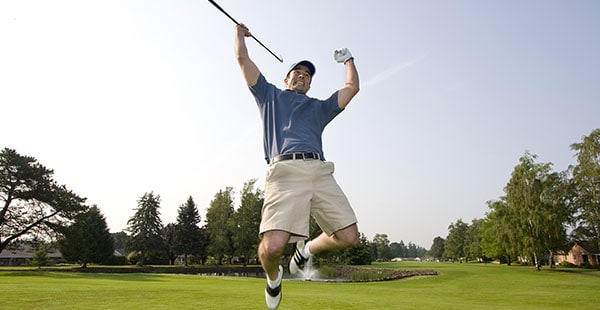 Golfer jumping in the air in victory 