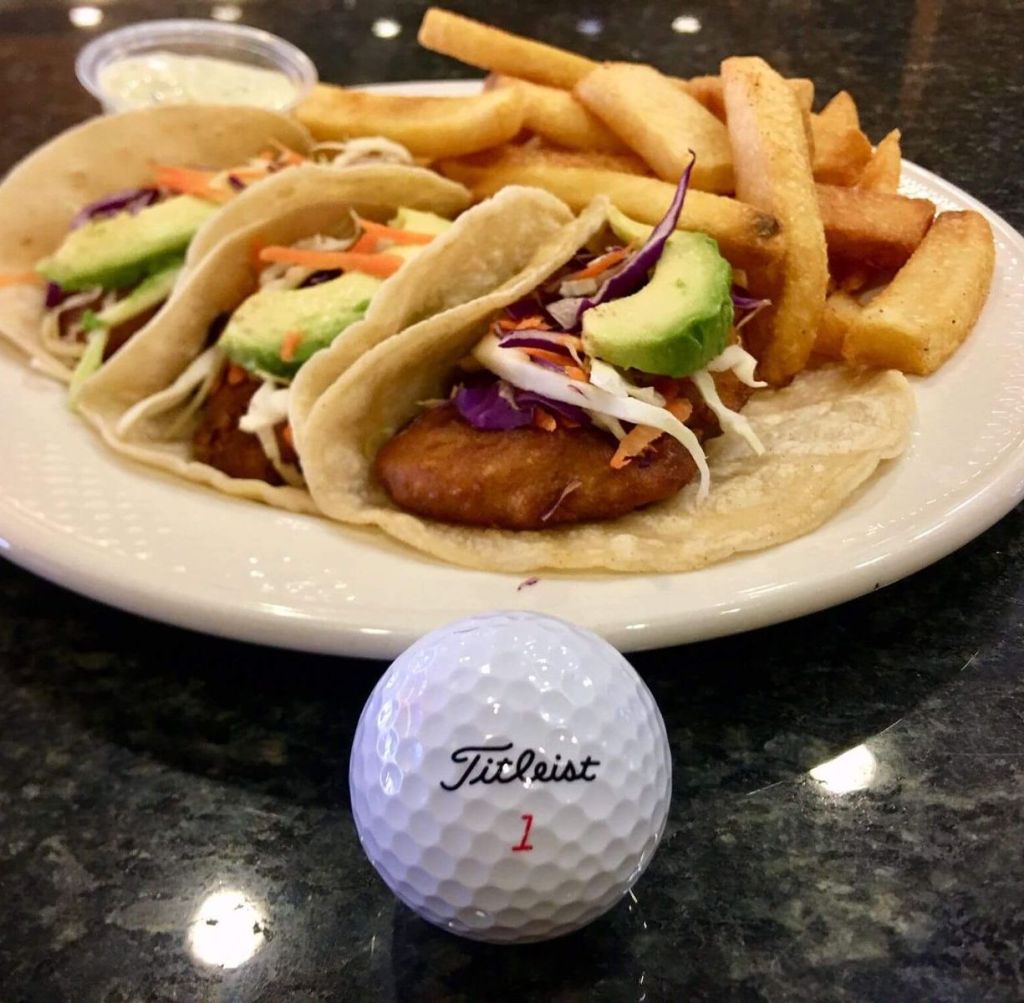 Tacos fries plated behind a Titleist golf club